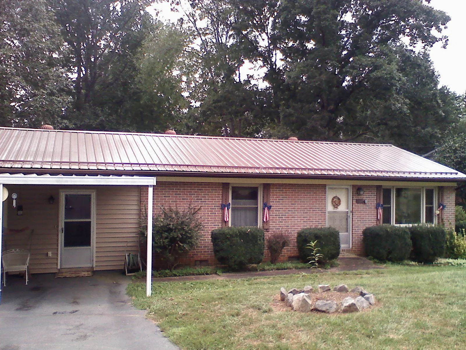 Bronze metal roof and carport on a brick ranch home — Roof Repair work by our crew in Billings
